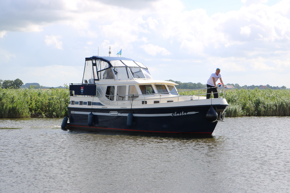 Bootsverleih Friesland Pikmeer-Kreuzer auf dem Sneekermeer mit Person davor.